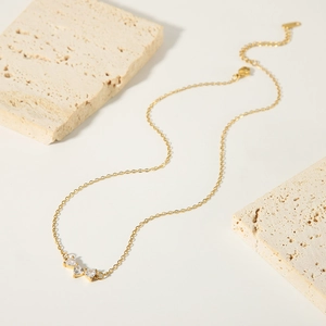 Elegant gold-plated stainless steel necklace with three heart-shaped cubic zirconia stones