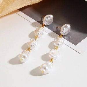 Detailed view of long baroque pearl drop earrings with four cascading irregular pearls