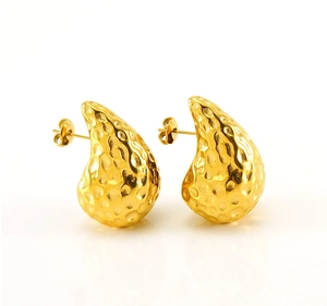 Detail of 18K gold teardrop earrings featuring a unique hammered irregular texture