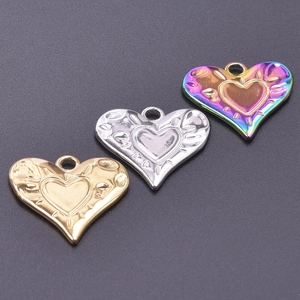 Macro shot of stainless steel heart pendants in gold, silver, and iridescent finishes