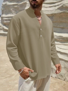 Detail of light khaki linen shirt featuring a buttoned Henley neck and textured fabric