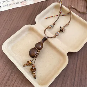 Vintage wooden gourd pendant necklace with handmade beads on a minimalist background