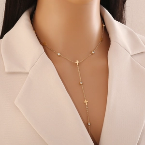 Élégant collier doré en Y avec pendentif croix et cristal sur un mannequin féminin