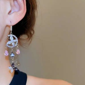 Detail of long tassel earrings with butterfly floral design and colorful zircons