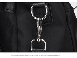 Detail of silver polished lobster clasp and D-ring on a durable black nylon shoulder bag