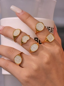Details von fünf 18K vergoldeten Siegelringen mit pavé Herz und geometrischen Zirkonia