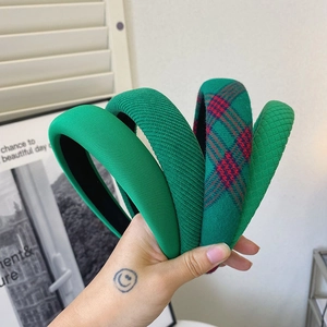 Close-up of four green padded headbands with knit, ribbed, plaid, and quilted textures