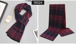 Detail of red and black plaid wool scarf with fringe tassels and folded texture