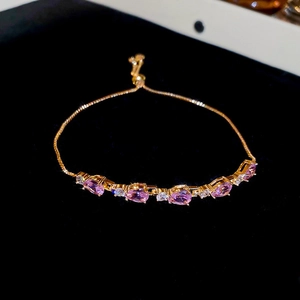 Élégant bracelet doré ajustable avec cinq zircons roses en forme de larme et pierres blanches