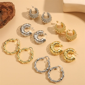 Variety of C-shaped metal hoop earrings in gold and silver finishes with textured designs