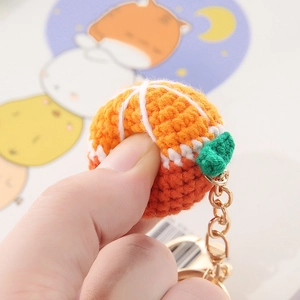 Handmade orange crochet fruit keychain with green leaf and golden metal chain link