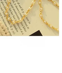 Macro shot of eye-shaped golden metal hollow links featuring white mini round pearls