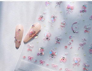 Detail view of 3D embossed nail art stickers with strawberries, bows and rhinestones
