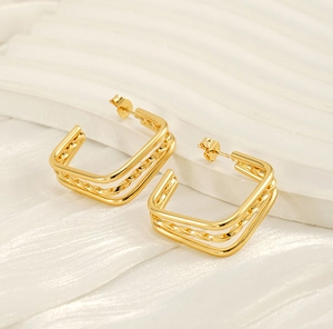 Close-up of triple-layered gold titanium earrings with twisted rope and polished design