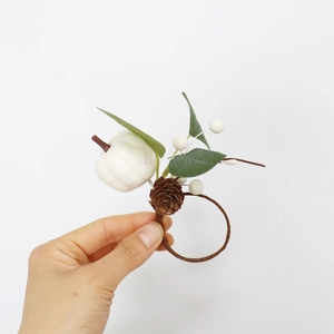 Detailed view of white pumpkin napkin ring with pine cones and eucalyptus leaves decor