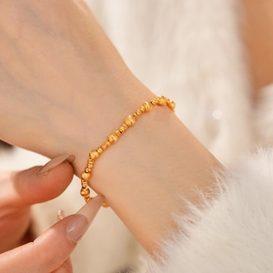 Detail of 24k gold plated bracelet with smooth and textured beads on model wrist