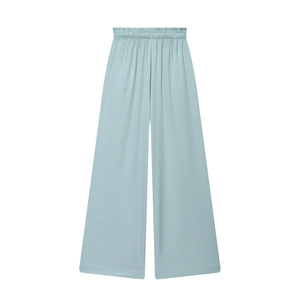 Detail of light blue wide-leg trousers featuring elastic waist and fluid drape fabric