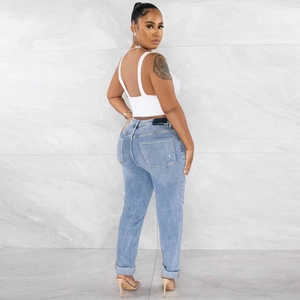 Women's backless white tank top and light blue ripped jeans outfit set on model
