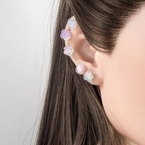 Exquisite resin camellia ear studs with iridescent finish on model's ear
