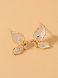 Close-up of S925 sterling silver stamp on golden butterfly earrings with white enamel