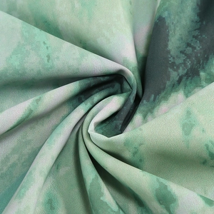 Dettaglio del tessuto in raso verde acquerello con trama fine e pieghe eleganti