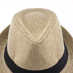 Close-up of beige woven fedora hat crown featuring a fine texture and black ribbon band