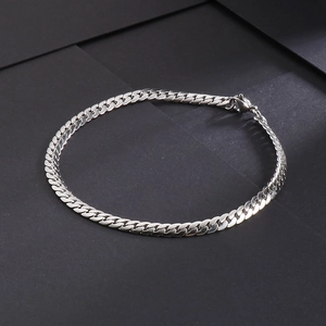 Detailed top view of a minimalist silver stainless steel Cuban link bracelet on grey background