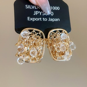 Macro shot of 18k gold plated crystal stud earrings with intricate woven chain detail