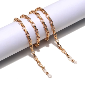 Golden geometric textured square link metal eyewear chain and mask holder on display