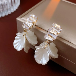 Boucles d'oreilles fleur élégantes avec cristaux et dorure sur une boîte à bijoux