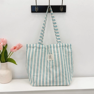 Close-up of blue and white striped canvas tote bag with decorative fabric patch