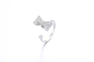 Macro detail of silver rotating bow ring with sparkling zircon and adjustable open band