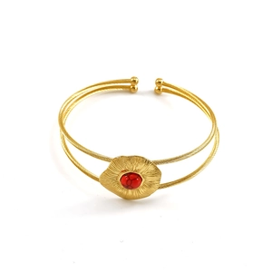 Gold titanium steel rope bracelet with red gemstone inlay in a minimalist luxury design