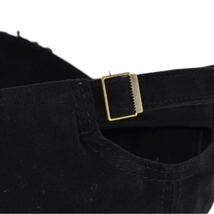 Close-up of the vintage bronze metal buckle and cotton fabric texture on a black cap