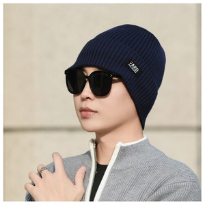 Close-up of deep blue ribbed knit beanie with brand label and stylish sunglasses