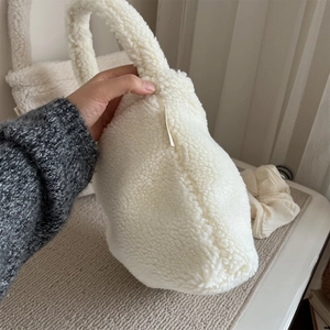 Close-up of fluffy white faux fur handbag with a thick soft handle for winter styling