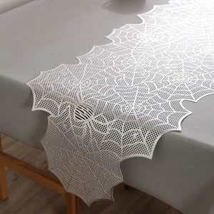 Close-up of metallic silver spider web table runner with laser-cut hollow spider pattern