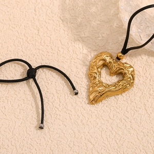 Macro shot of 18K gold-plated hollow heart pendant with hammered lava texture