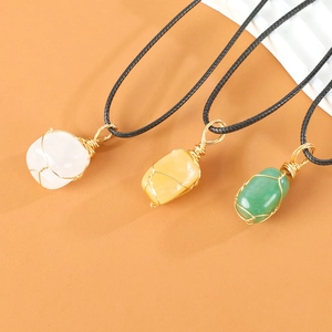 Handgemaakte ketting met hanger van natuurlijk kristal en zwart koord op oranje achtergrond