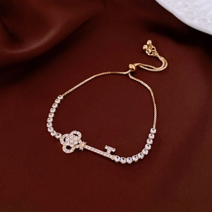 Macro view of gold key bracelet with zircon pave and adjustable slider on velvet