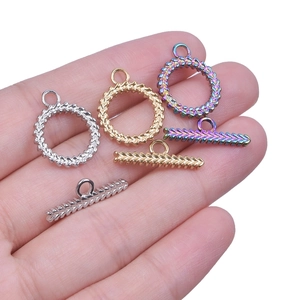 Stainless steel OT toggles in gold, silver, and iridescent finishes on hand
