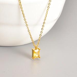 Golden stainless steel necklace with emerald-cut yellow zircon on white ceramic