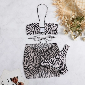Detailed flat lay of a zebra print three-piece bikini set with a drawstring beach skirt