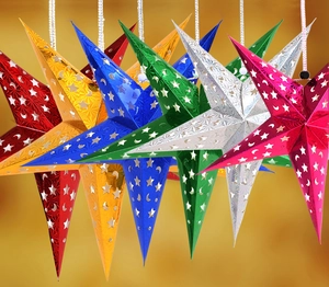 Detail of laser cut 3D paper star lanterns with hollow moon and star patterns for Christmas