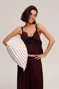 Detail of burgundy satin sleepwear set with black lace trim and V-neckline design