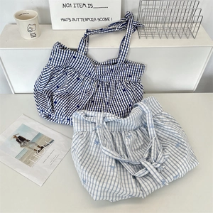 Detail view of plaid tote bags with floral bows and drawstring ruffled opening
