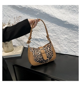 Detail of leopard print patchwork shoulder bag with leather trim and metallic buckle