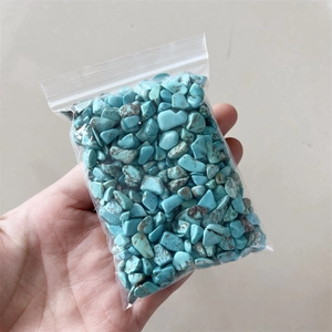 Detailed view of hand holding a bag of blue and brown natural crushed crystal stones