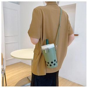 Lifestyle shot of a creative green bubble tea shaped crossbody bag worn by a model
