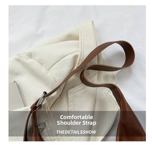 Detailed close-up of smooth brown leather shoulder strap and silver metal buckle on tote bag